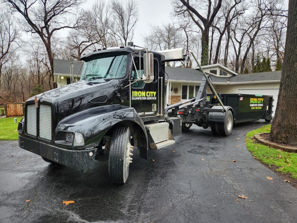 Iron City Service truck with a dumpster being delivered to a home in Mishawaka